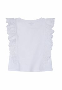 Vit bomullströja med dekorativa ögonlitslöss längs axlarna, rund halsringning och rak nederkant.