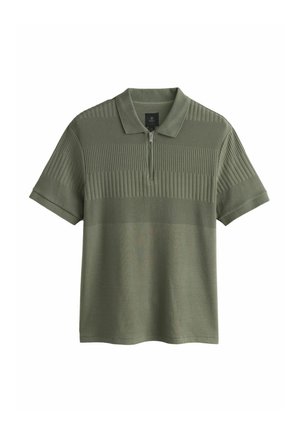 Olivzaļš polo krekls ar īsām piedurknēm, rāvējslēdzēja apkakli un teksturētām horizontālām svītrām krūšu un augšējā ķermeņa daļā.