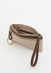 Monedero de cuero beige con cremallera dorada, detalle en marrón y cadena. Cuenta con múltiples compartimentos y un enganche para llaves.