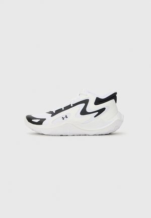 Chaussure de sport blanche avec des accents noirs, présentant une tige en mesh texturé, un design courbé et une semelle en caoutchouc avec un profil de traction.