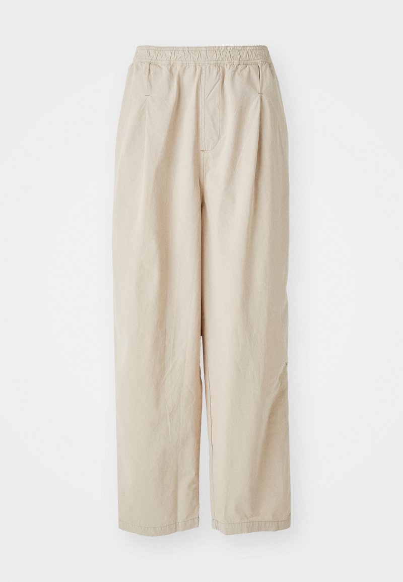 Beige, high-waisted broek met een gestructureerde afwerking, voorzien van een elastische tailleband en zijzakken, ontworpen voor een losse pasvorm.