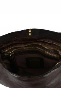 Innenansicht einer braunen Ledertasche mit goldenen Reißverschlüssen und Metallnieten. Verfügt über mehrere Fächer und eine weiche, strukturierte Oberfläche.