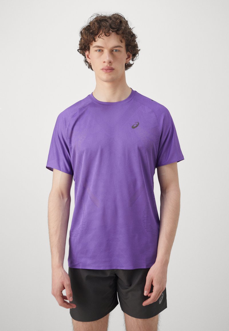 Lila Sportshirt mit kurzen Ärmeln aus leichtem, strukturiertem Material. Verfügt über wiederholende geometrische Muster und ein kleines Logo auf der linken Brust.