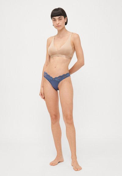 Beige draadloze bh van gladde stof met een dark blue tanga en kant aan de randen, met een lage taille en kleine decoratieve accenten.