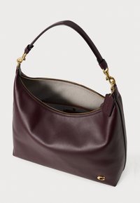 Borsa in pelle bordeaux con una texture liscia, design curvo, hardware color oro e una zip superiore. Interno di una tonalità più chiara di beige.