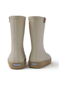 Un paio di stivali di gomma beige con suole marroni visti da dietro su uno sfondo bianco.