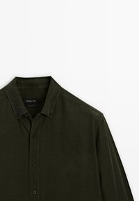 Camicia a maniche lunghe verde scuro con colletto abbottonato, caratterizzata da una texture morbida e da un piccolo logo etichettato sul colletto.