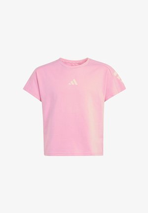 Mädchen läuft mit einem schwarzen Rucksack, trägt ein pinkes Shirt, schwarze Leggings mit Logo und schwarze Sneakers mit weißen Streifen.