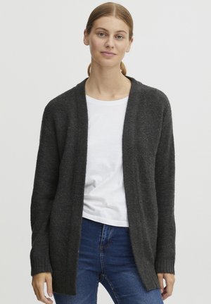 Cardigan ouvert gris foncé en tissu tricoté doux, avec des manches longues et des poignets côtelés, superposé à un t-shirt blanc.
