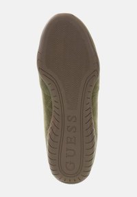 Podeszwa buta w ciemnooliwkowym gumowym materiale, z tłoczonym wzorem bieżnika i wytłoczonym logo "GUESS" dla lepszej przyczepności i identyfikacji marki.