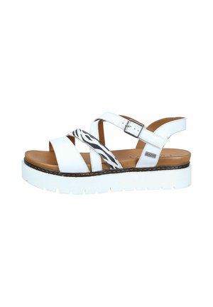 White platform sandal with brown footbed, adjustable ankle strap, and black-and-white zebra strap detail across the front.