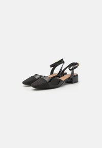 Črne slingback pete z zgornjim delom iz lakirane usnje in teksturirano tkanino na konici. Kvadratna blok peta in nastavljiv gleženjski trak.