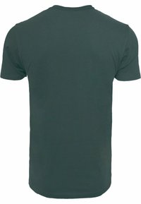 T-shirt verde scuro a maniche corte realizzato in cotone, con collo tondo standard e una consistenza liscia e uniforme, priva di motivi o decorazioni.
