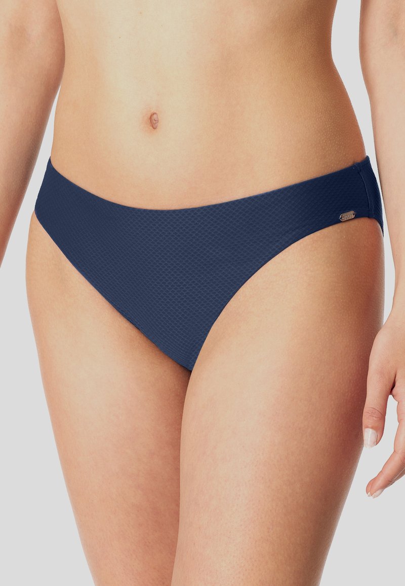 Marineblaues Bikini-Unterteil aus einem strukturierten Stoff, mit niedrigem Bund und minimaler Bedeckung sowie einem kleinen metallischen Logo-Detail.