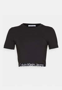 Mustat puuvillaiset lyhyet hihat cropped-t-paita, jossa on pyöreä kaula-aukko ja valkoinen logonauha helmassa, jossa lukee "Calvin Klein Jeans."