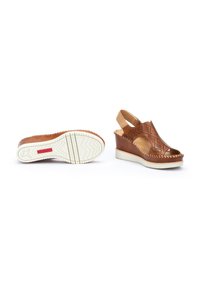 Sandales compensées marron avec des découpes, une sangle arrière, et une semelle en caoutchouc blanc texturé ornée de motifs en zigzag.