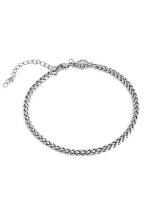 Bracelet en chaîne argentée avec maillons en chevron, fermoir à boucle ajustable et breloque décorative en forme de lotus sur fond blanc.