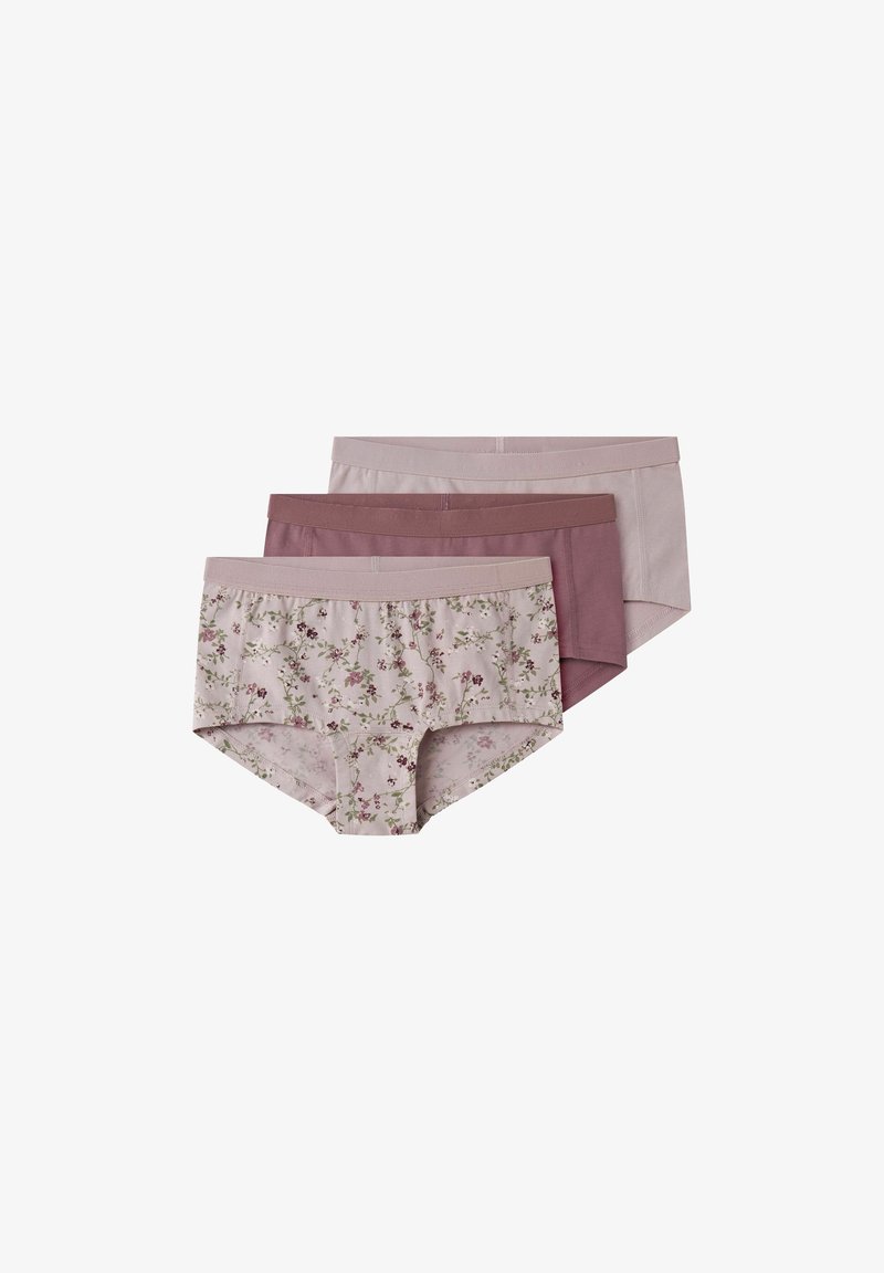 Trois culottes hipster pour femmes dans des tons roses atténués, une avec un motif floral et deux unies, empilées sur un fond blanc.