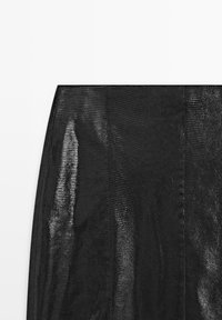 Schwarzer Mesh-Rock mit strukturiertem, durchscheinendem Design. Glatte Kanten, tailliert mit schmalem Bund, ohne sichtbare Beschläge oder Akzente.