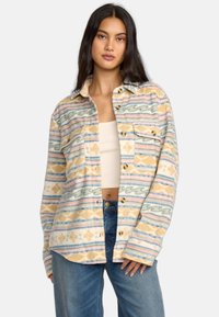 Flanellhemd mit mehrfarbigem Muster, das horizontale Streifen in Pastellfarben mit Wellen- und geometrischen Designs zeigt, zwei vordere Taschen, Knopfverschluss.