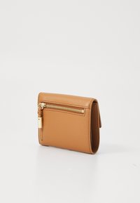 Portefeuille en cuir tan avec une surface texturée, doté d'une fermeture éclair en or sur un côté et d'un design compact et plié.