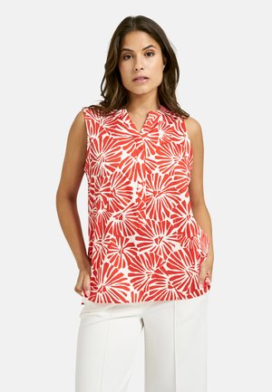 Ärmellose Bluse im rot-weißen Blumenmuster, mit einem Schalkragen und lockerer Passform. Das Material wirkt leicht und hat eine glatte Textur.