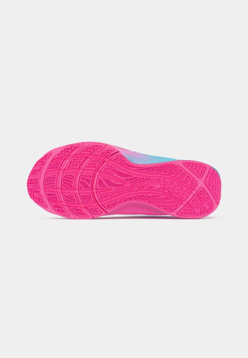 Suela de goma texturizada de color rosa brillante de una zapatilla deportiva azul, mostrada en plano con el patrón de la banda de rodadura visible sobre un fondo blanco.
