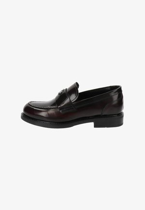 Mocassin en cuir bourgogne sombre avec un bout arrondi, fente traditionnelle pour pièce de monnaie, couture subtile et petit talon en caoutchouc noir.