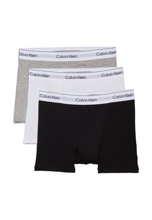 Tři páry boxerky v šedé, bílé a černé barvě. Každý pár má elastický pas se značkou "Calvin Klein" vytištěnou tmavým písmem.