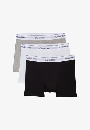 Tres pares de calzoncillos tipo bóxer en gris, blanco y negro. Cada uno cuenta con una cinturilla elástica con "Calvin Klein" impresa en letras oscuras.