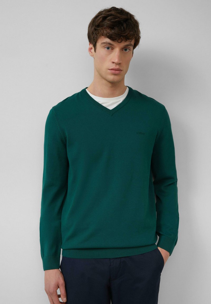 Grüner V-Ausschnitt-Pullover aus weichem Strickstoff, mit langen Ärmeln und taillierter Passform. Dezente Markenkennzeichnung auf der Brust.
