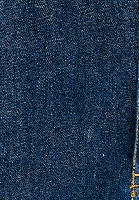 Tessuto di denim blu scuro con un classico motivo a tela di ragno, che presenta una consistenza liscia e leggere sfumature chiare.