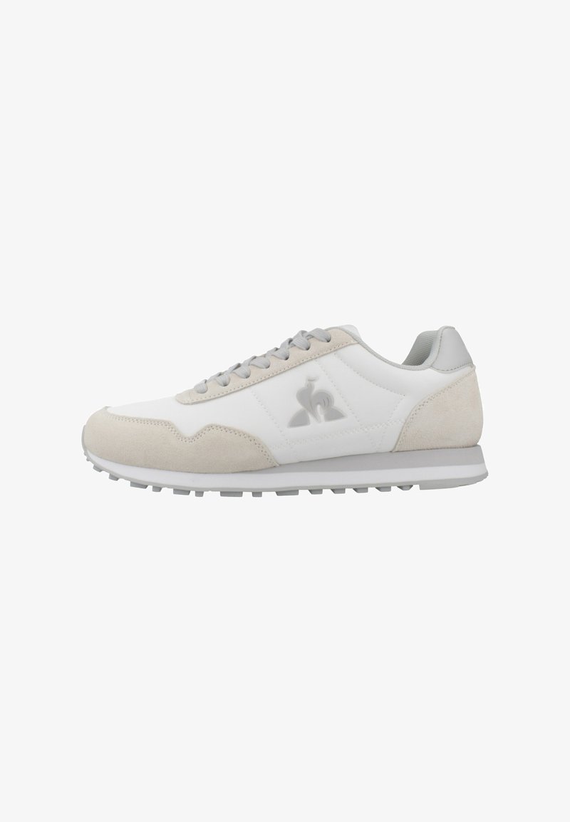 Sneaker aus weißem Leder und hellgrauem Wildleder, mit einer strukturierten Sohle, flachen Schnürsenkeln und einem Logo an der Seite.