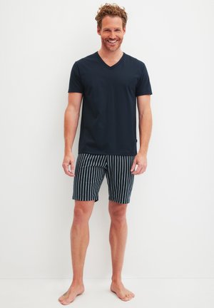 Marineblaue V-Ausschnitt-T-Shirts kombiniert mit schwarz-weißen gestreiften Shorts. Der Stoff wirkt glatt, und die Shorts haben einen Kordelzugbund.