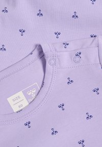 Bawełniana koszula w kolorze lawendowym z małymi, granatowymi wzorami kwiatowymi, okrągły dekolt i zapięcie na zatrzaski. Metka rozmiarowa wskazuje "80".