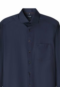 Donkerblauwe langetermijnshirt van textuurstof met een knoopsluiting kraag, een borstzak en bruine knopen op de sluiting.