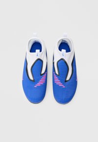 Μπλε παπούτσια slip-on με λευκές λεπτομέρειες  και υφασμένο επάνω μέρος. Διαθέτουν ροζ ρίγες σε αντίθεση και μαύρο περίγραμμα κατά μήκος των πλευρών.