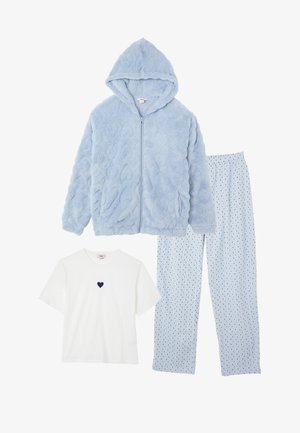 Himmelblaues, flauschiges Zip-Up-Hoodie, himmelblaue Hose mit kleinen dunklen Herzmustern und weißem T-Shirt mit kurzen Ärmeln und einem dunklen Herz auf der Brust.
