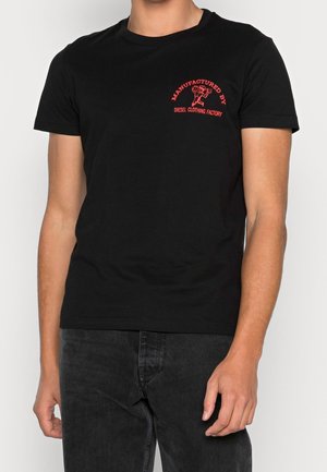 Camiseta de algodón negra con mangas cortas, cuello redondo y gráfico rojo "Fabricado por Diesel Clothing Factory" en la parte superior izquierda.