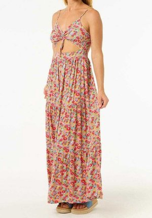 Woman wearing a sleeveless floral maxi dress with a front cutout and knot detail, paired with platform sandals.