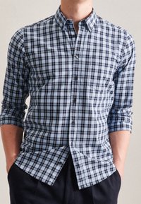 Blå och marinblå rutiga skjortor med knappar, lång ärm, knapp-ner krage och en ficka på vänster bröst. Mjuk bomullstyg.