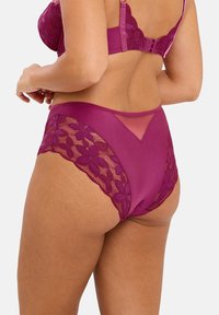 Culotte mi-hauteur en magenta profond avec des bordures en dentelle florale et des accents en maille, présentant un devant lisse et un dos décoratif en transparent.