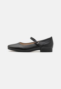 Schwarze Leder-Mary-Jane-Schuhe mit runder Zehenpartie, niedrigem Blockabsatz und verstellbarem Riemen über dem Spann. Glatte Textur und minimales Design.
