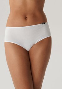 Białe bawełniane majtki typu boyshort o gładkiej strukturze, z bezszwowym pasem i małą metką z logo po boku.