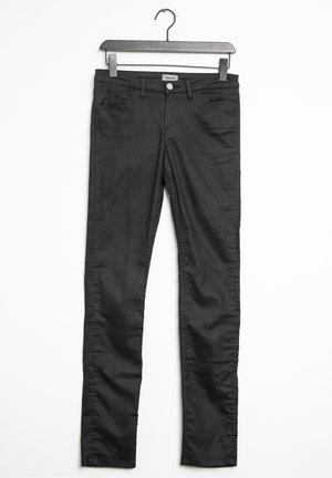 Black denim skinny jeans with subtle sheen, five pockets, a front button closure, and belt loops, hanging from a black hanger.