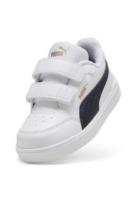 Hvide Puma sneakers med marineblå accenter, velcro remme, perforeret tåhætte og tekstureret læder. Guld branding på tungen og siden.