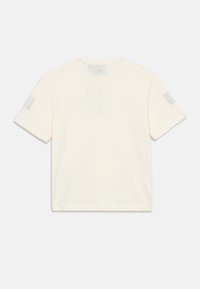 Kreemikas lühikeste varrukatega t-särk, valmistatud puuvillast. Omab ümarat kaelust ja triibulisi aktsente varrukatel. Lihtne, kastikujuline disain.