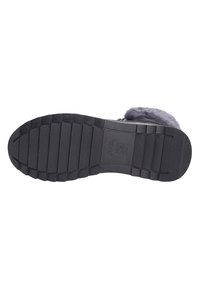 Semelle de chaussure en caoutchouc noir avec un motif de grip texturé, présentant des rainures horizontales et verticales pour l'adhérence. Accents texturés et lisses.