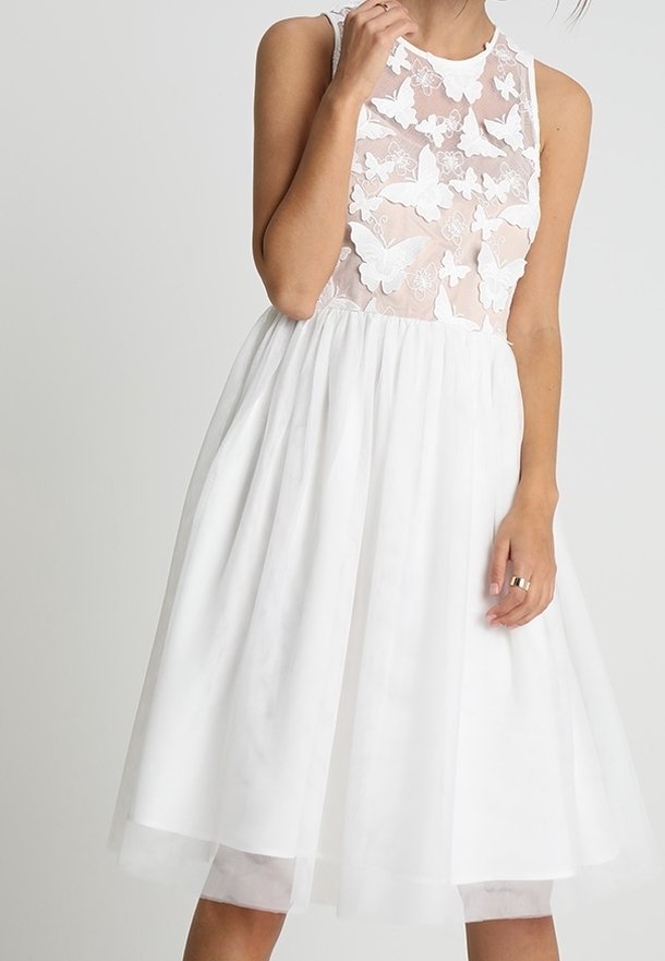 Robe blanche sans manches avec un corsage transparent orné d'appliques texturées en forme de papillons et une jupe ample mi-longue.