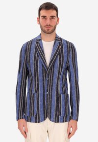 Blazer a righe blu e nere con linee bianche accentuate, due tasche frontali e rever a punta. Chiusura a due bottoni con tessuto testurizzato.